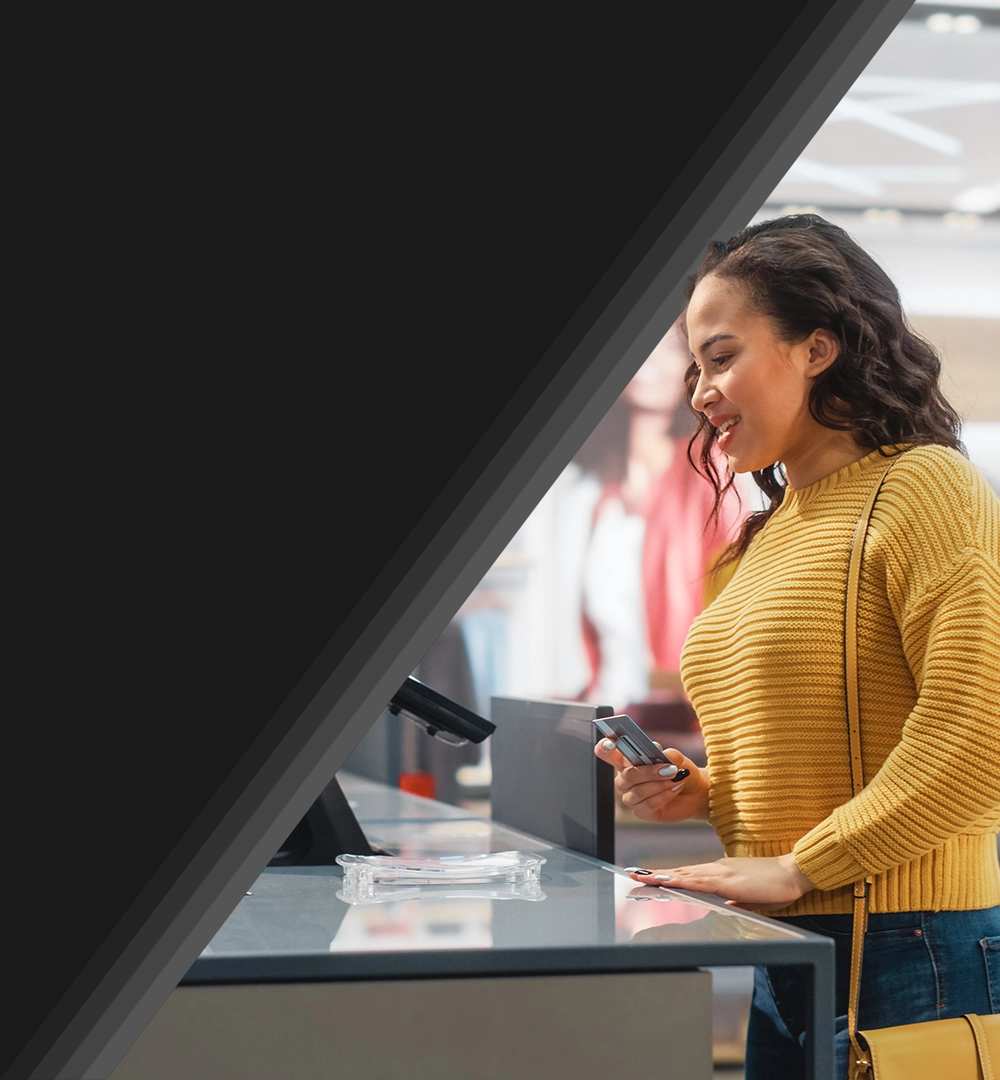young female customer about to use her phone to make a purchase at a register.